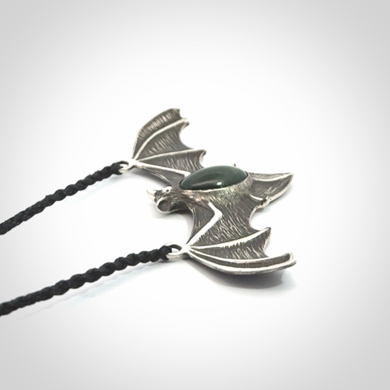 This is a hand carved bat pendant. It is made from New Zealand Jade and Sterling Silver. This is a medium sized necklace and is a very unique, one only, pendant that is a collectors piece. Provided with black adjustable cord.