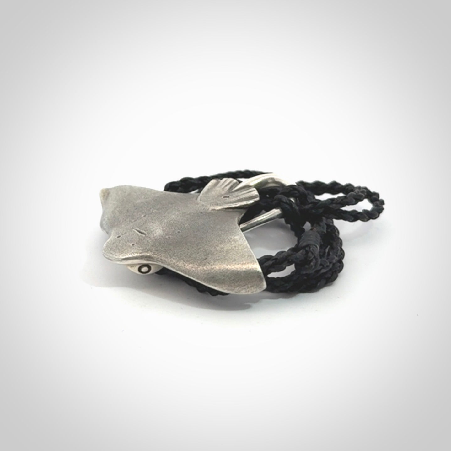 This is a hand carved Sterling Silver Eagle Ray pendant with New Zealand Jade insert. This is a medium sized necklace and is provided with an adjustable black cord.