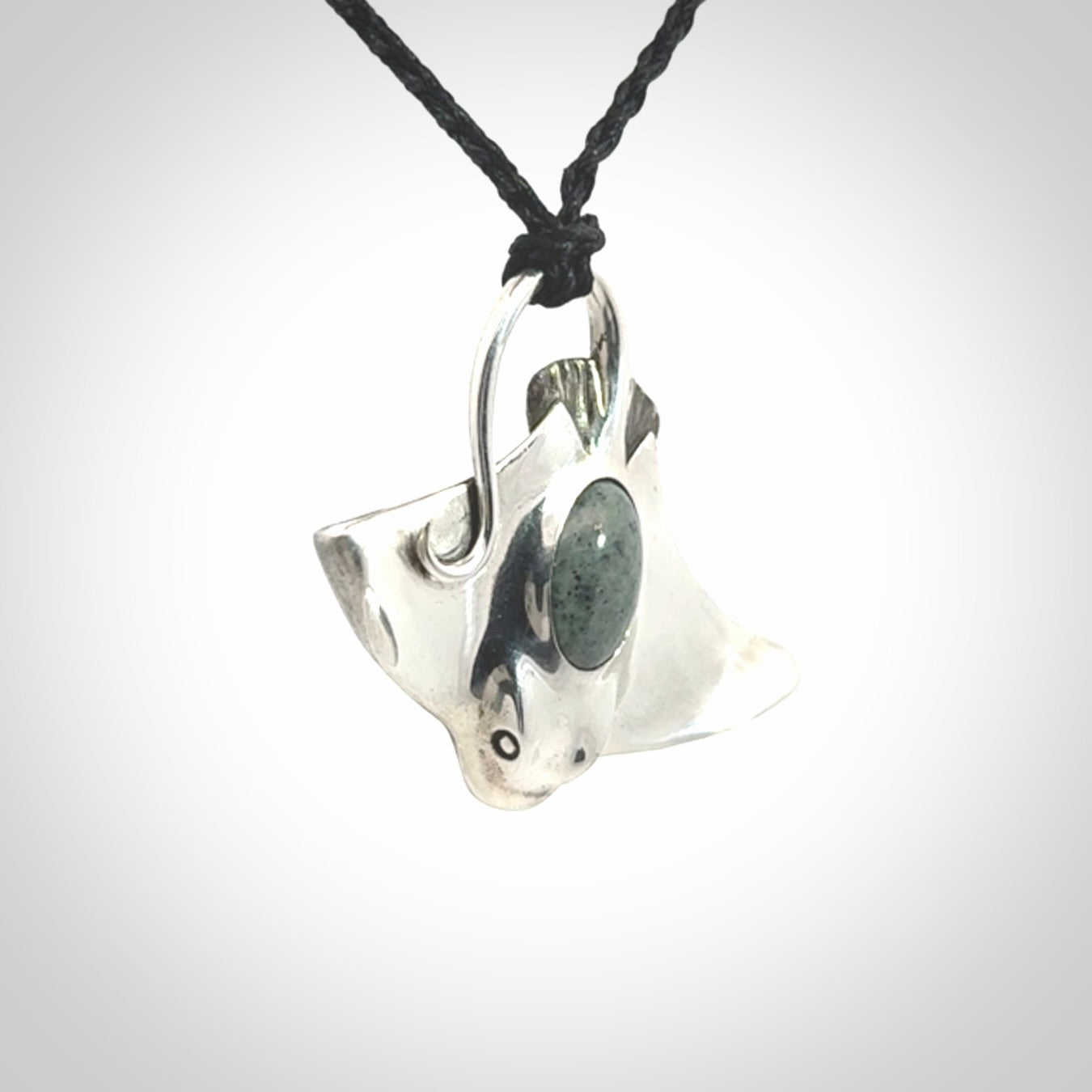 This is a hand carved Sterling Silver Eagle Ray pendant with New Zealand Jade insert. This is a medium sized necklace and is provided with an adjustable black cord.