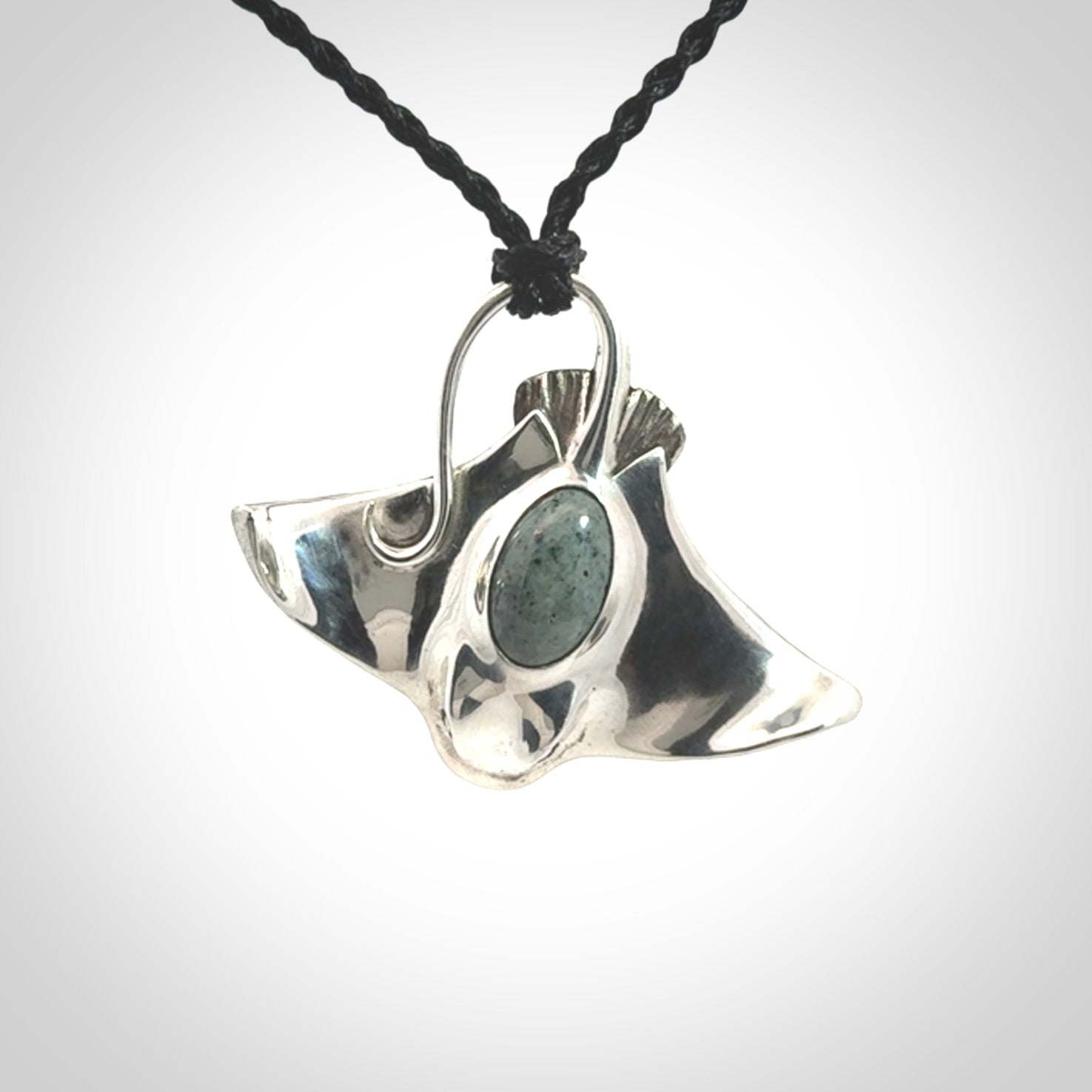 This is a hand carved Sterling Silver Eagle Ray pendant with New Zealand Jade insert. This is a medium sized necklace and is provided with an adjustable black cord.