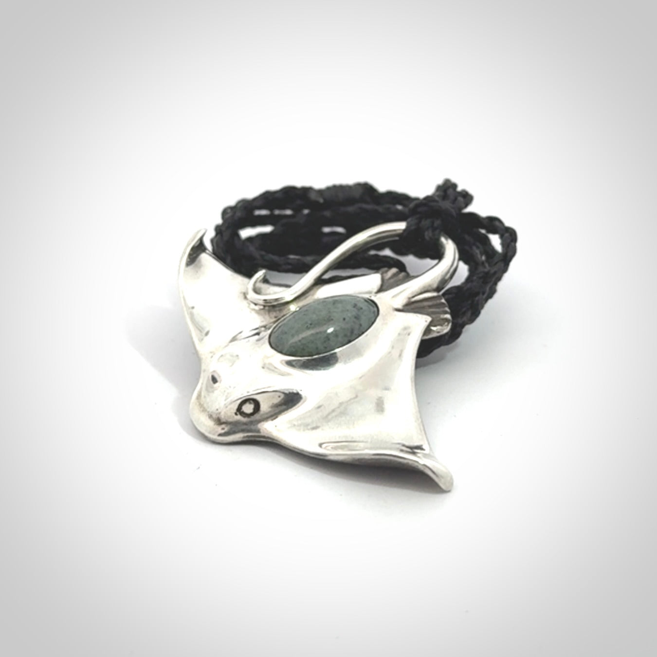This is a hand carved Sterling Silver Eagle Ray pendant with New Zealand Jade insert. This is a medium sized necklace and is provided with an adjustable black cord.