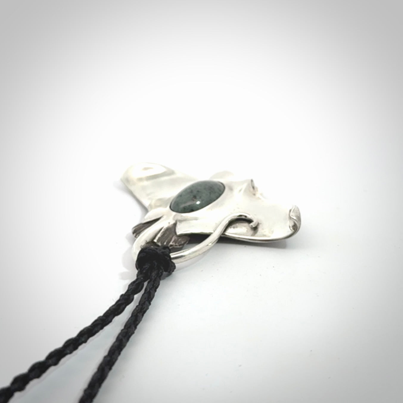 This is a hand carved Sterling Silver Eagle Ray pendant with New Zealand Jade insert. This is a medium sized necklace and is provided with an adjustable black cord.