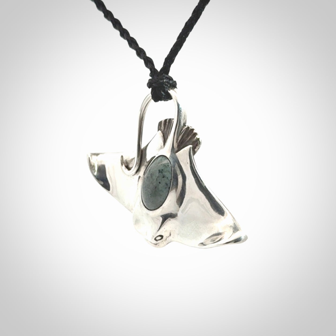 This is a hand carved Sterling Silver Eagle Ray pendant with New Zealand Jade insert. This is a medium sized necklace and is provided with an adjustable black cord.