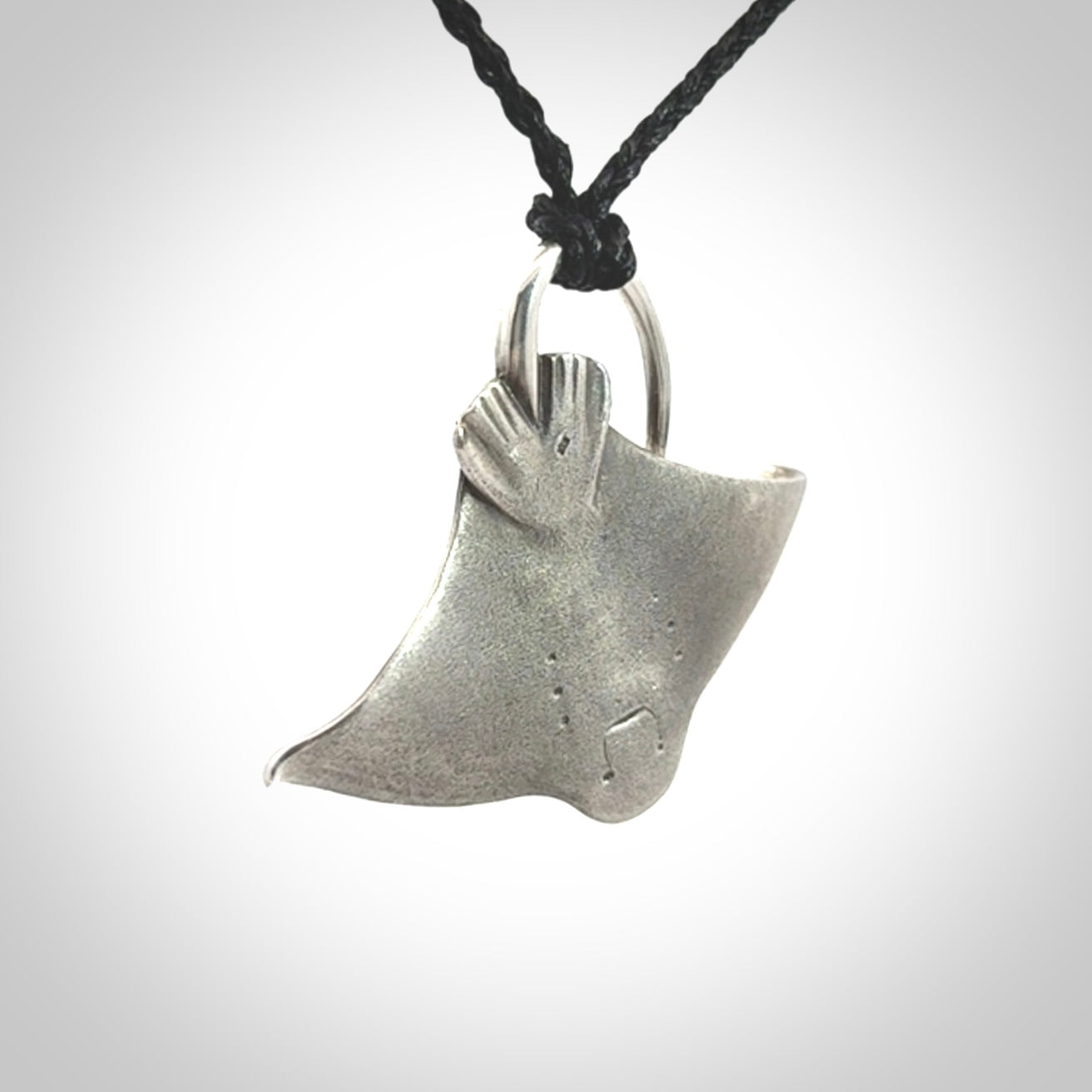 This is a hand carved Sterling Silver Eagle Ray pendant with New Zealand Jade insert. This is a medium sized necklace and is provided with an adjustable black cord.