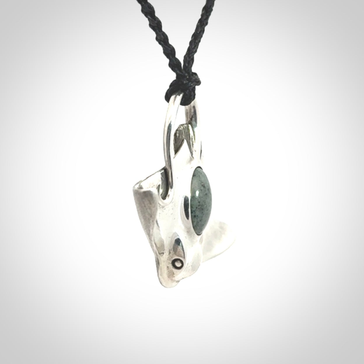 This is a hand carved Sterling Silver Eagle Ray pendant with New Zealand Jade insert. This is a medium sized necklace and is provided with an adjustable black cord.