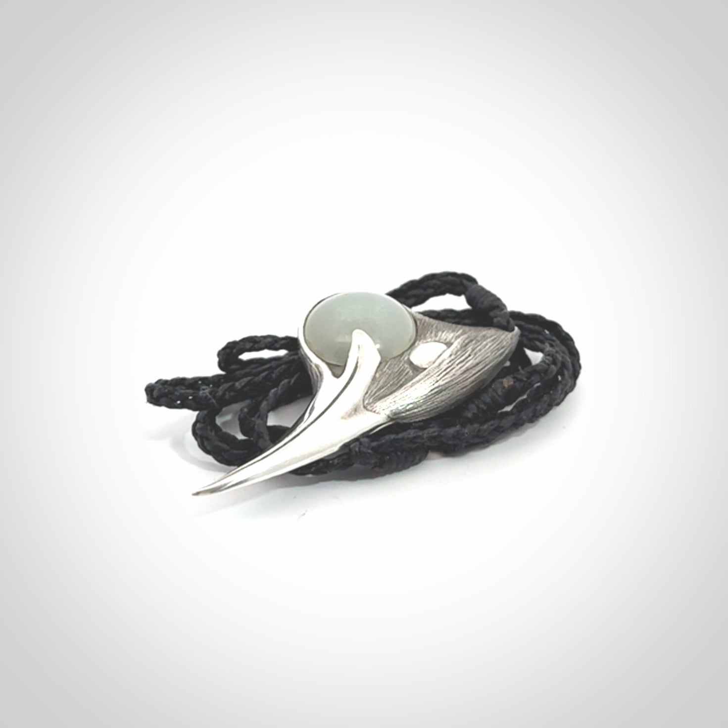 This is a hand carved Sterling Silver Huia bird pendant with Siberian Jade insert. This is a medium sized necklace and is provided with an adjustable black cord.