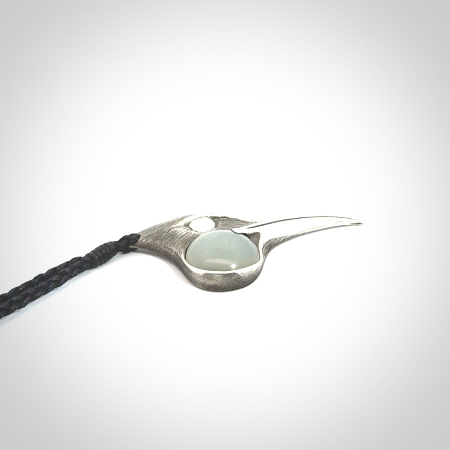 This is a hand carved Sterling Silver Huia bird pendant with Siberian Jade insert. This is a medium sized necklace and is provided with an adjustable black cord.