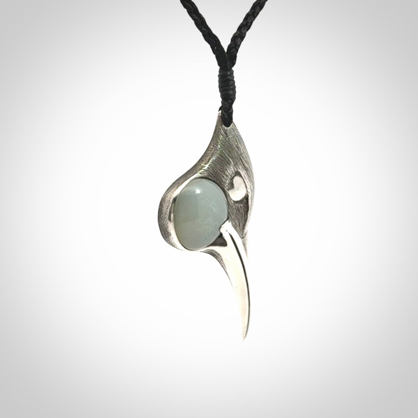 This is a hand carved Sterling Silver Huia bird pendant with Siberian Jade insert. This is a medium sized necklace and is provided with an adjustable black cord.