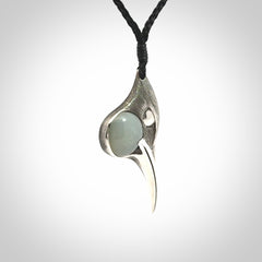 This is a hand carved Sterling Silver Huia bird pendant with Siberian Jade insert. This is a medium sized necklace and is provided with an adjustable black cord.