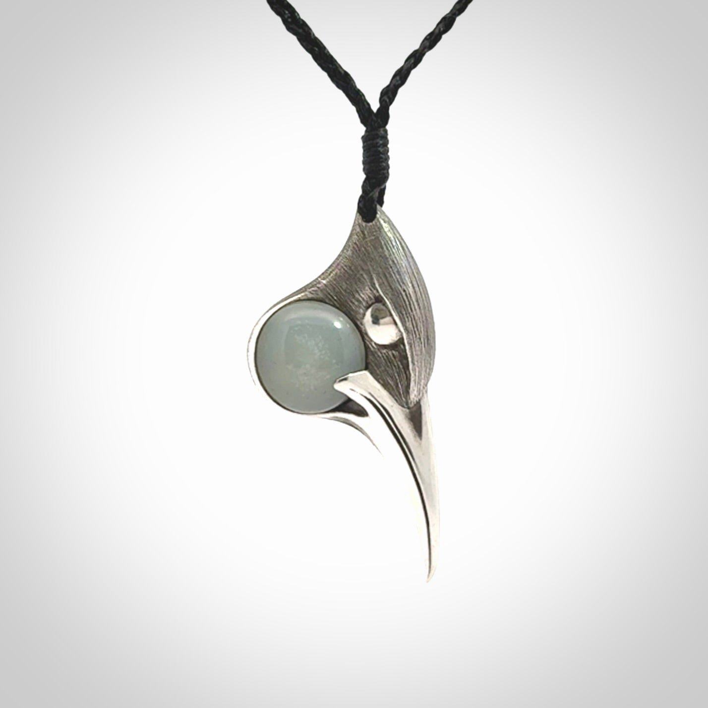 This is a hand carved Sterling Silver Huia bird pendant with Siberian Jade insert. This is a medium sized necklace and is provided with an adjustable black cord.