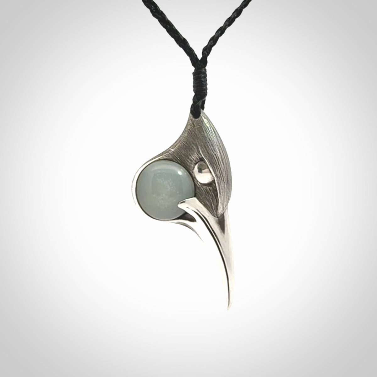 This is a hand carved Sterling Silver Huia bird pendant with Siberian Jade insert. This is a medium sized necklace and is provided with an adjustable black cord.