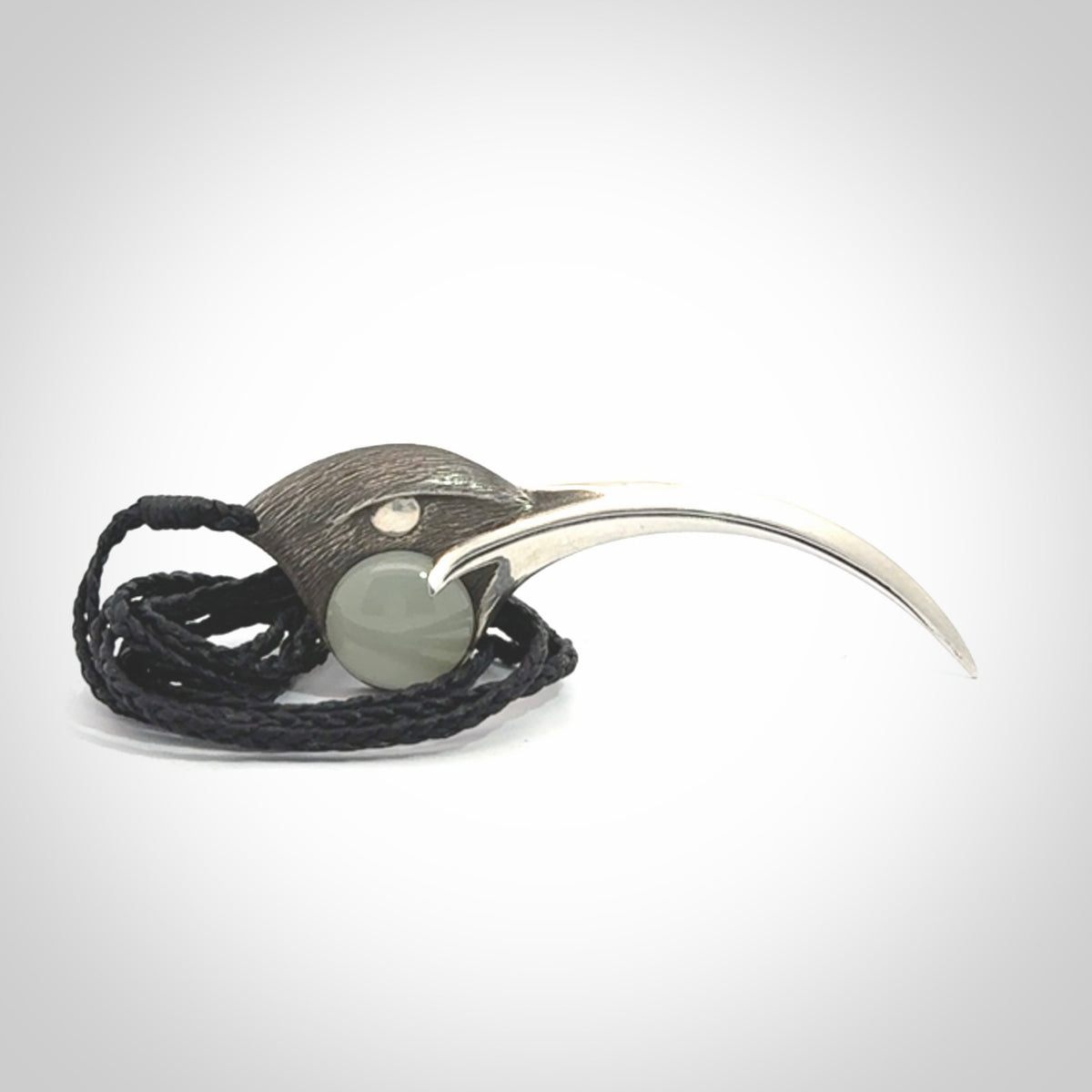 This is a hand carved Sterling Silver Huia bird pendant with Siberian Jade insert. This is a large sized necklace and is provided with an adjustable black cord.