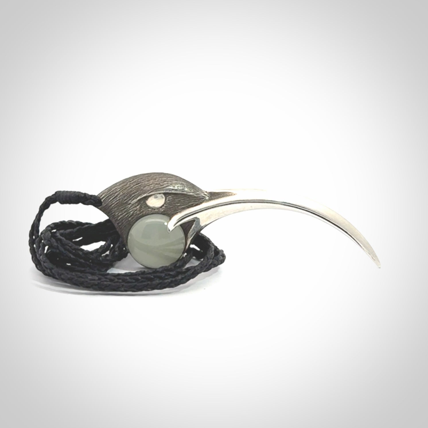 This is a hand carved Sterling Silver Huia bird pendant with Siberian Jade insert. This is a large sized necklace and is provided with an adjustable black cord.