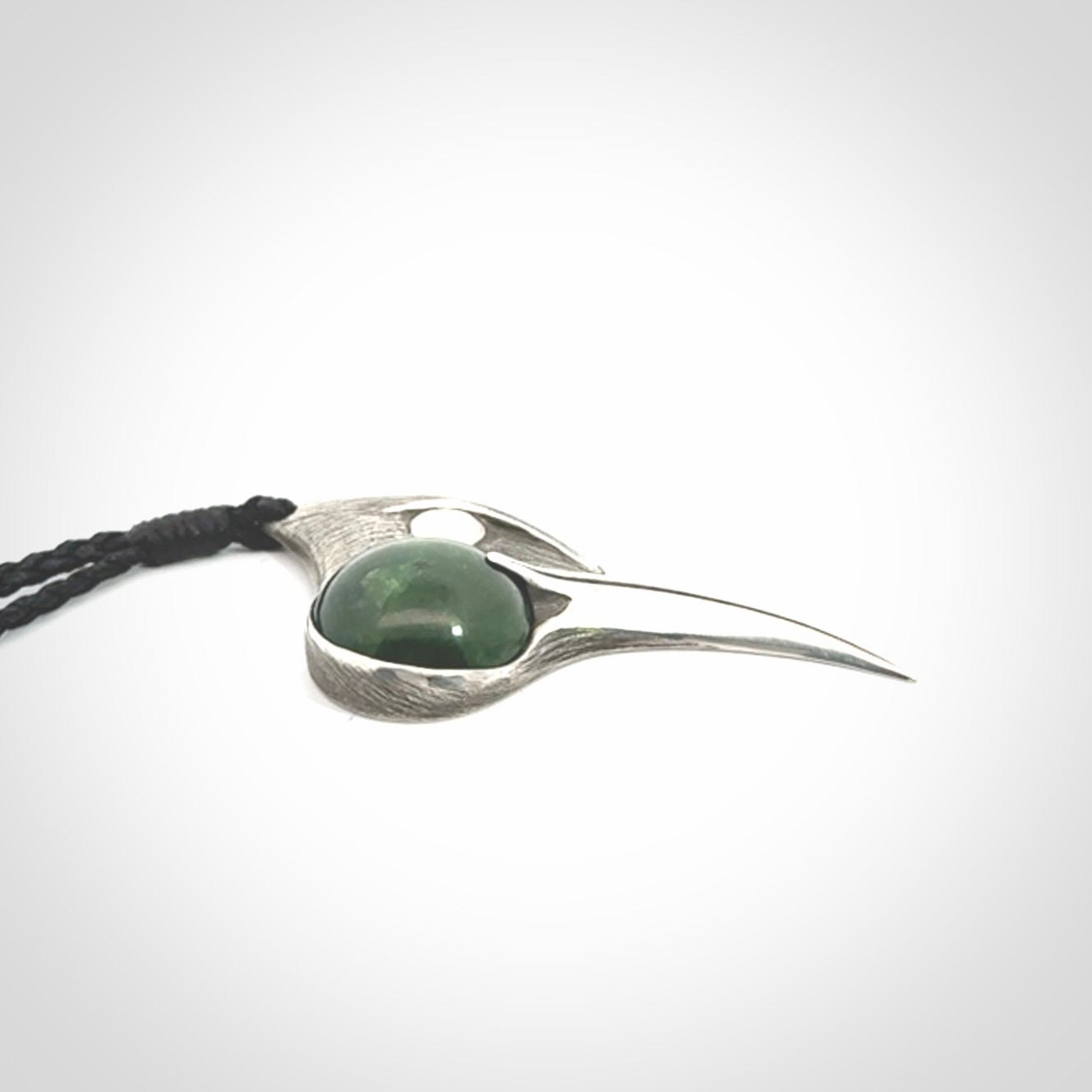 This is a hand carved Sterling Silver Huia bird pendant with New Zealand Jade insert. This is a medium sized necklace and is provided with an adjustable black cord.