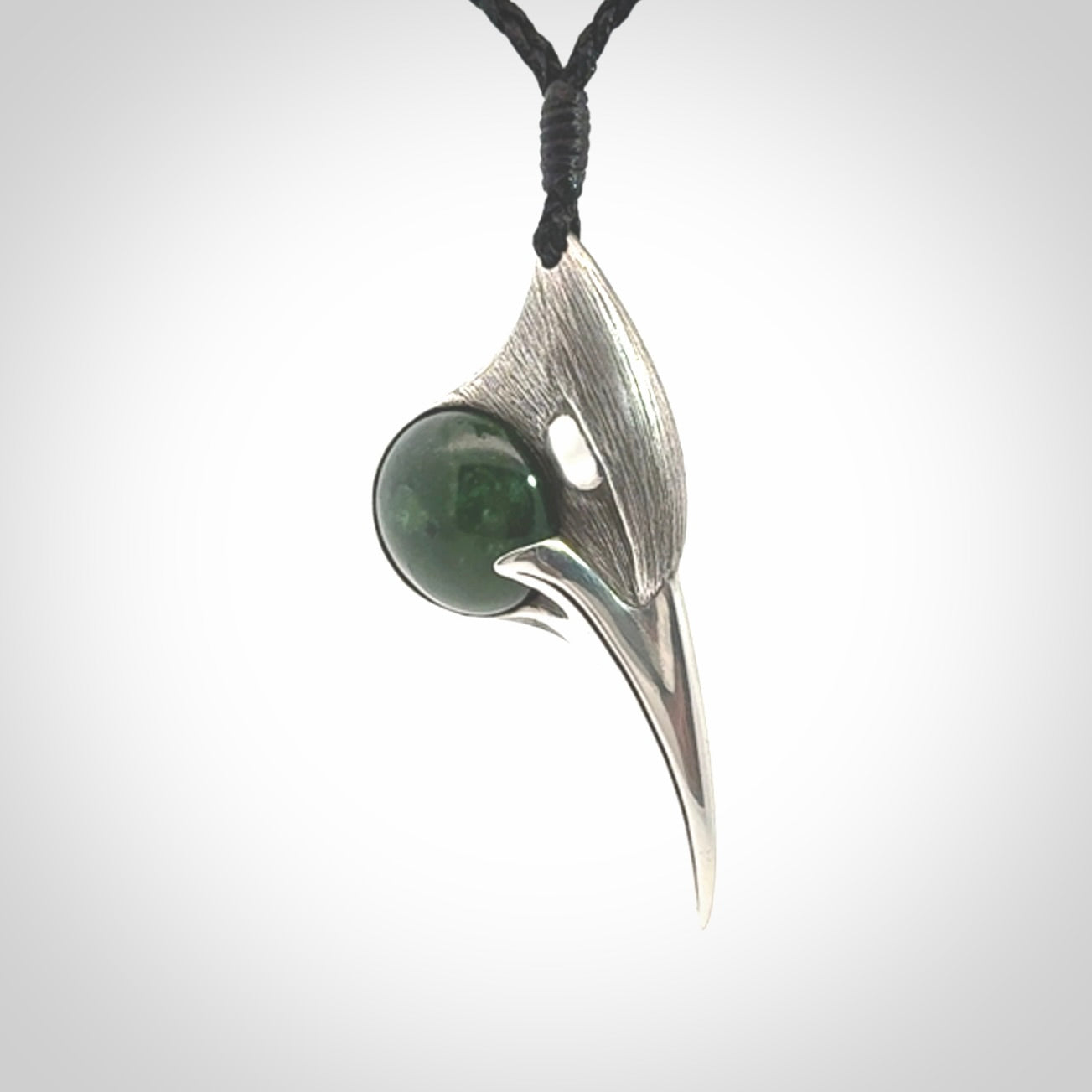 This is a hand carved Sterling Silver Huia bird pendant with New Zealand Jade insert. This is a medium sized necklace and is provided with an adjustable black cord.