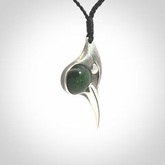 This is a hand carved Sterling Silver Huia bird pendant with New Zealand Jade insert. This is a medium sized necklace and is provided with an adjustable black cord.