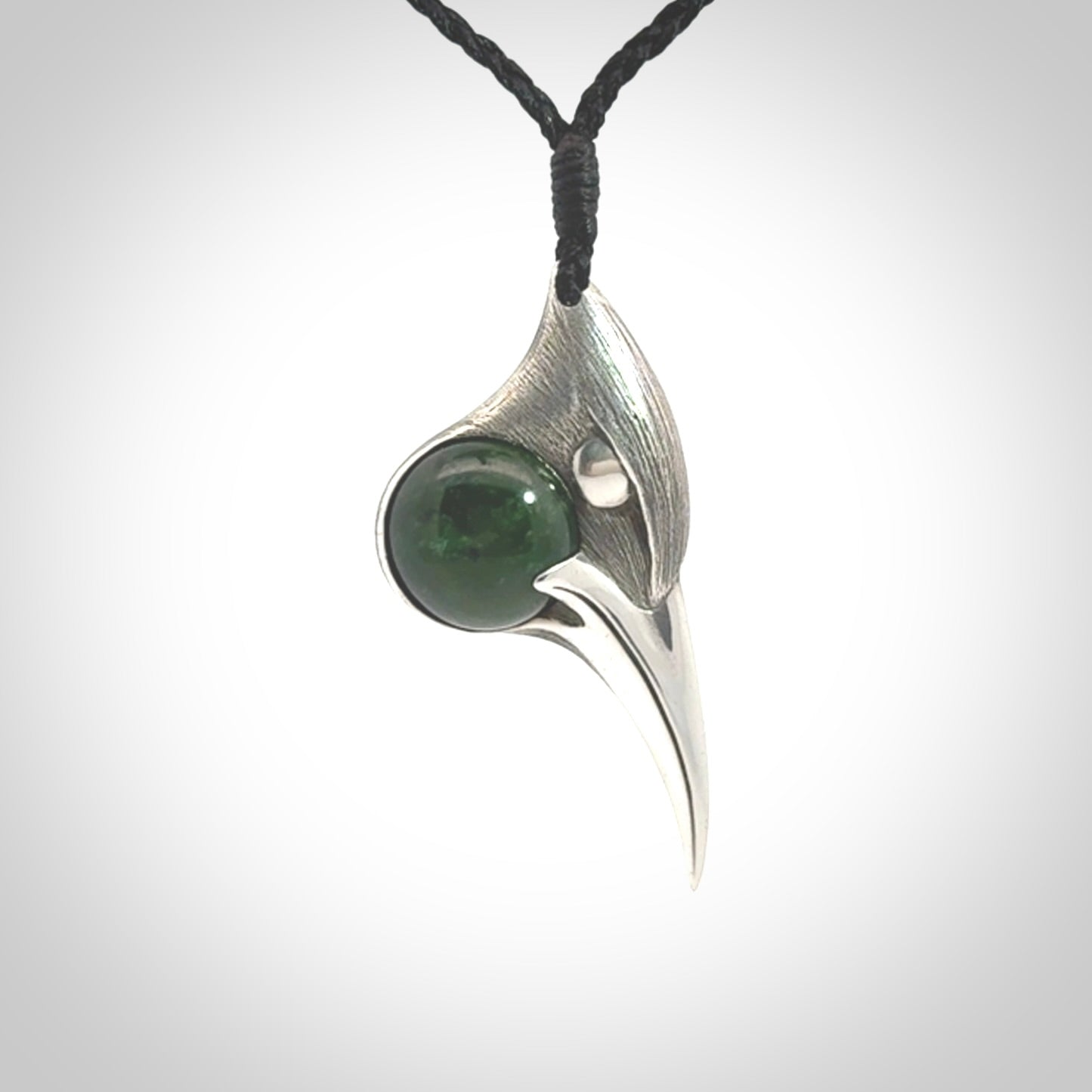 This is a hand carved Sterling Silver Huia bird pendant with New Zealand Jade insert. This is a medium sized necklace and is provided with an adjustable black cord.