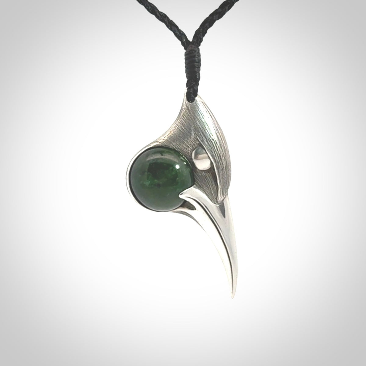 This is a hand carved Sterling Silver Huia bird pendant with New Zealand Jade insert. This is a medium sized necklace and is provided with an adjustable black cord.