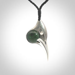 This is a hand carved Sterling Silver Huia bird pendant with New Zealand Jade insert. This is a medium sized necklace and is provided with an adjustable black cord.
