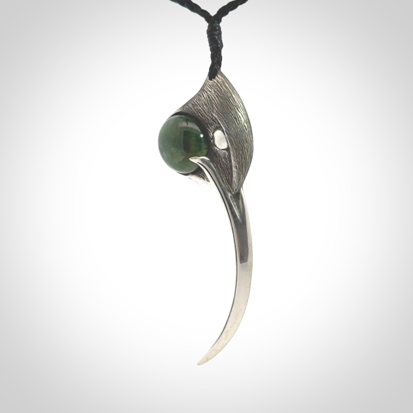 This is a hand carved Sterling Silver Huia bird pendant with New Zealand Jade insert. This is a large sized necklace and is provided with an adjustable black cord.