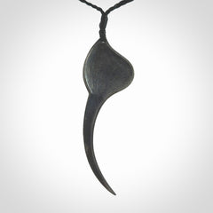 This is a hand carved Sterling Silver Huia bird pendant with New Zealand Jade insert. This is a large sized necklace and is provided with an adjustable black cord.