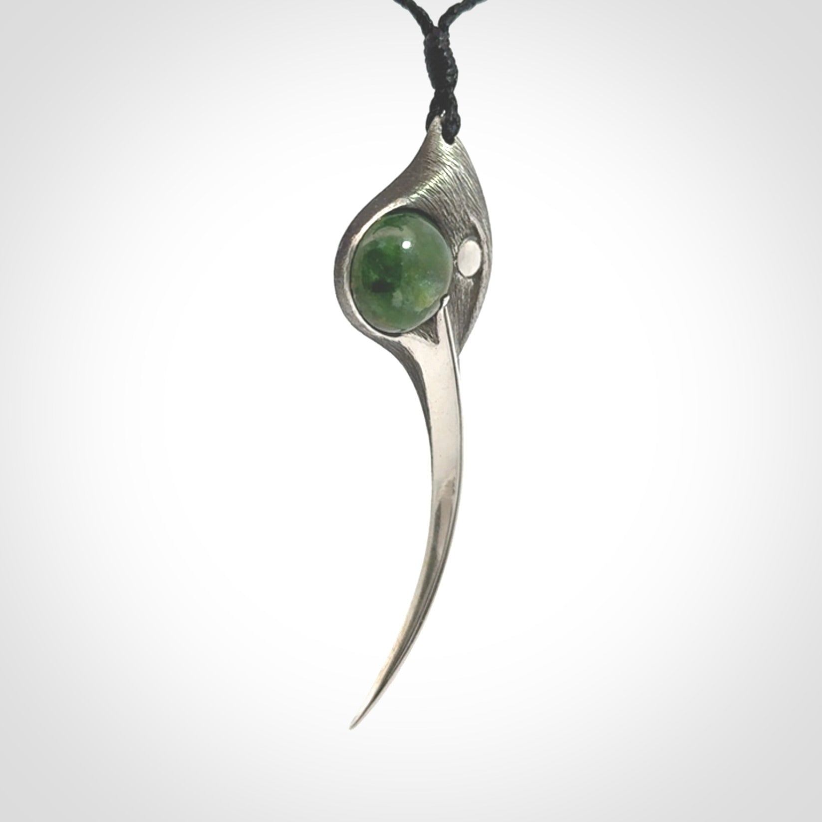 This is a hand carved Sterling Silver Huia bird pendant with New Zealand Jade insert. This is a large sized necklace and is provided with an adjustable black cord.