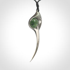 This is a hand carved Sterling Silver Huia bird pendant with New Zealand Jade insert. This is a large sized necklace and is provided with an adjustable black cord.