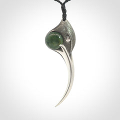 This is a hand carved Sterling Silver Huia bird pendant with New Zealand Jade insert. This is a large sized necklace and is provided with an adjustable black cord.