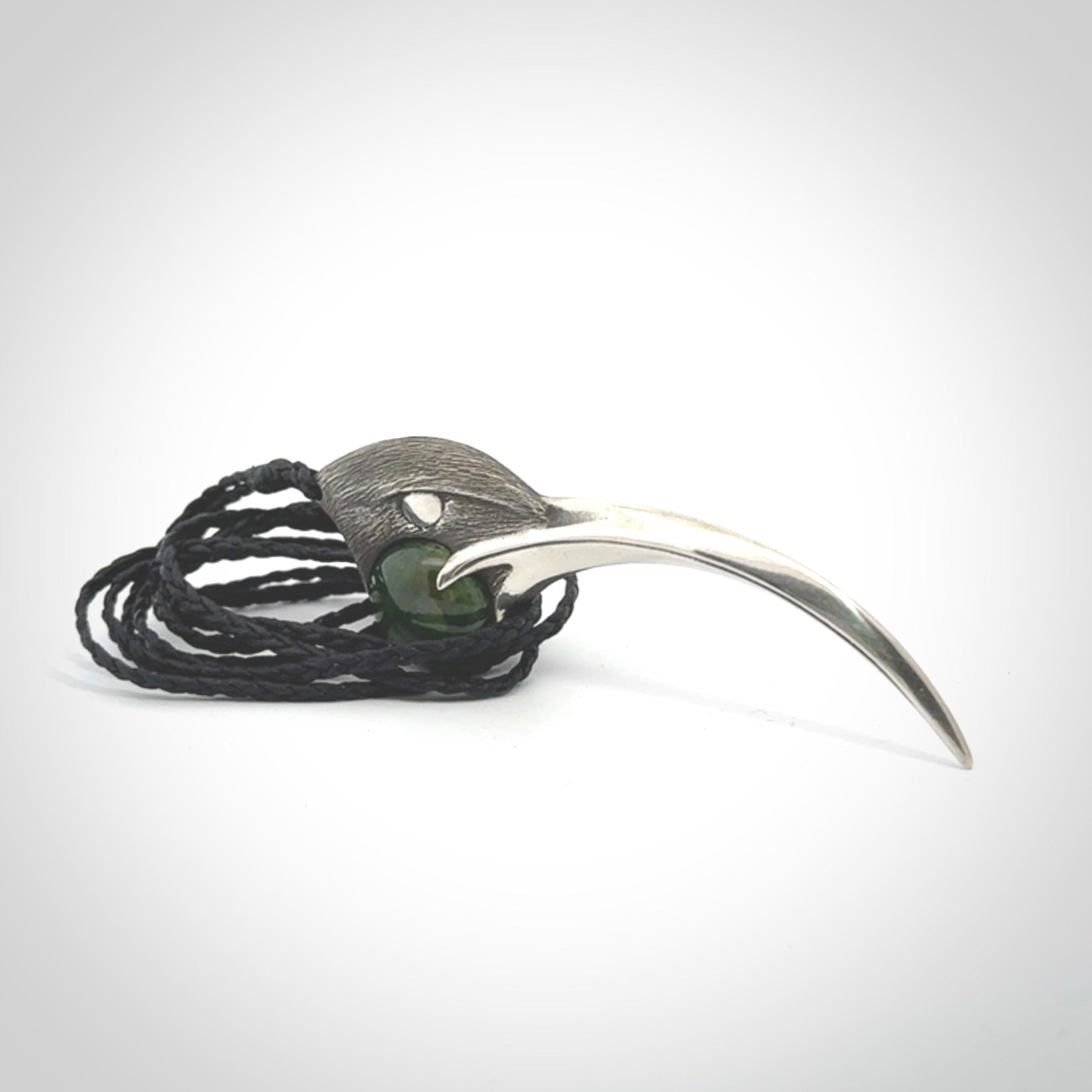 This is a hand carved Sterling Silver Huia bird pendant with New Zealand Jade insert. This is a large sized necklace and is provided with an adjustable black cord.