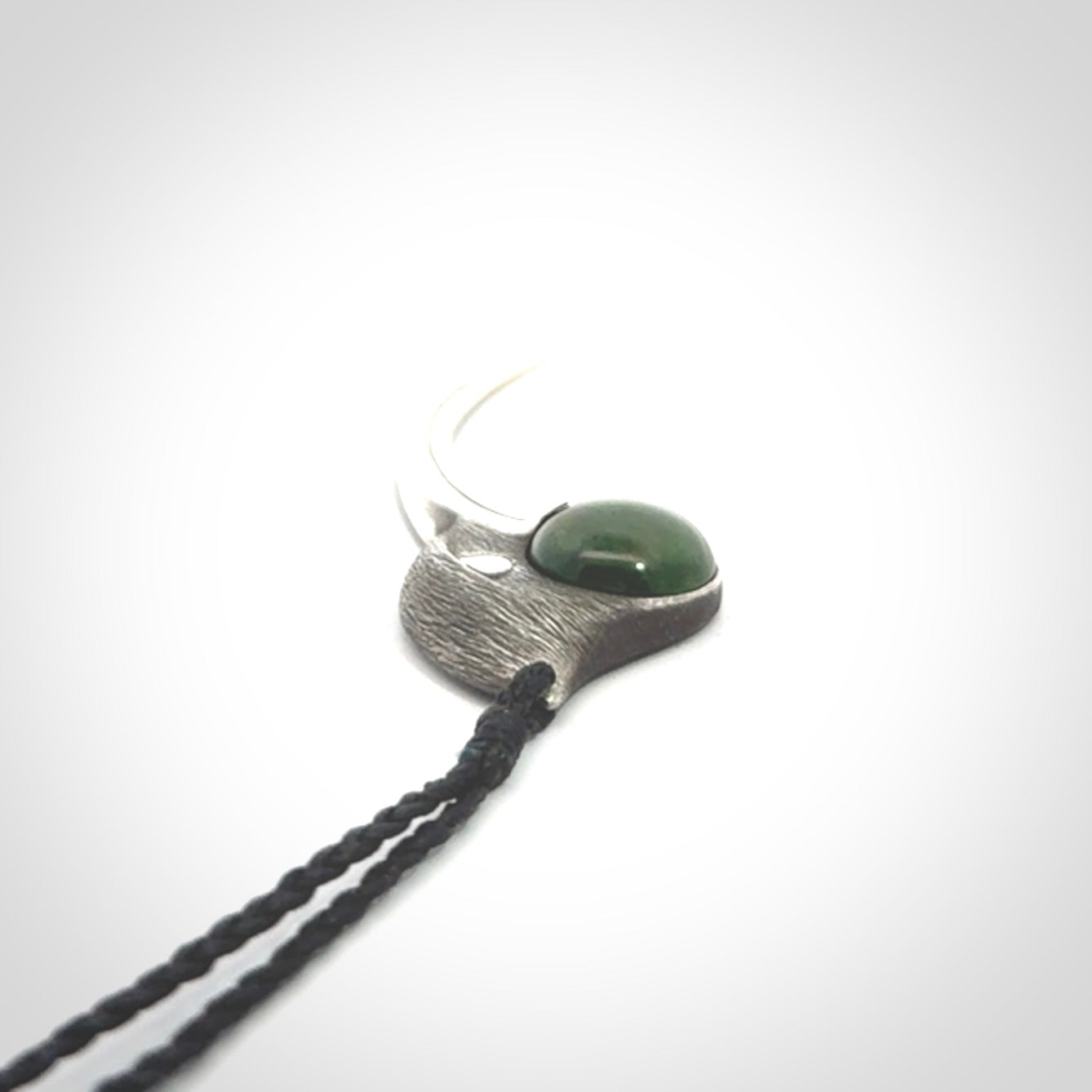 This is a hand carved Sterling Silver Huia bird pendant with New Zealand Jade insert. This is a large sized necklace and is provided with an adjustable black cord.