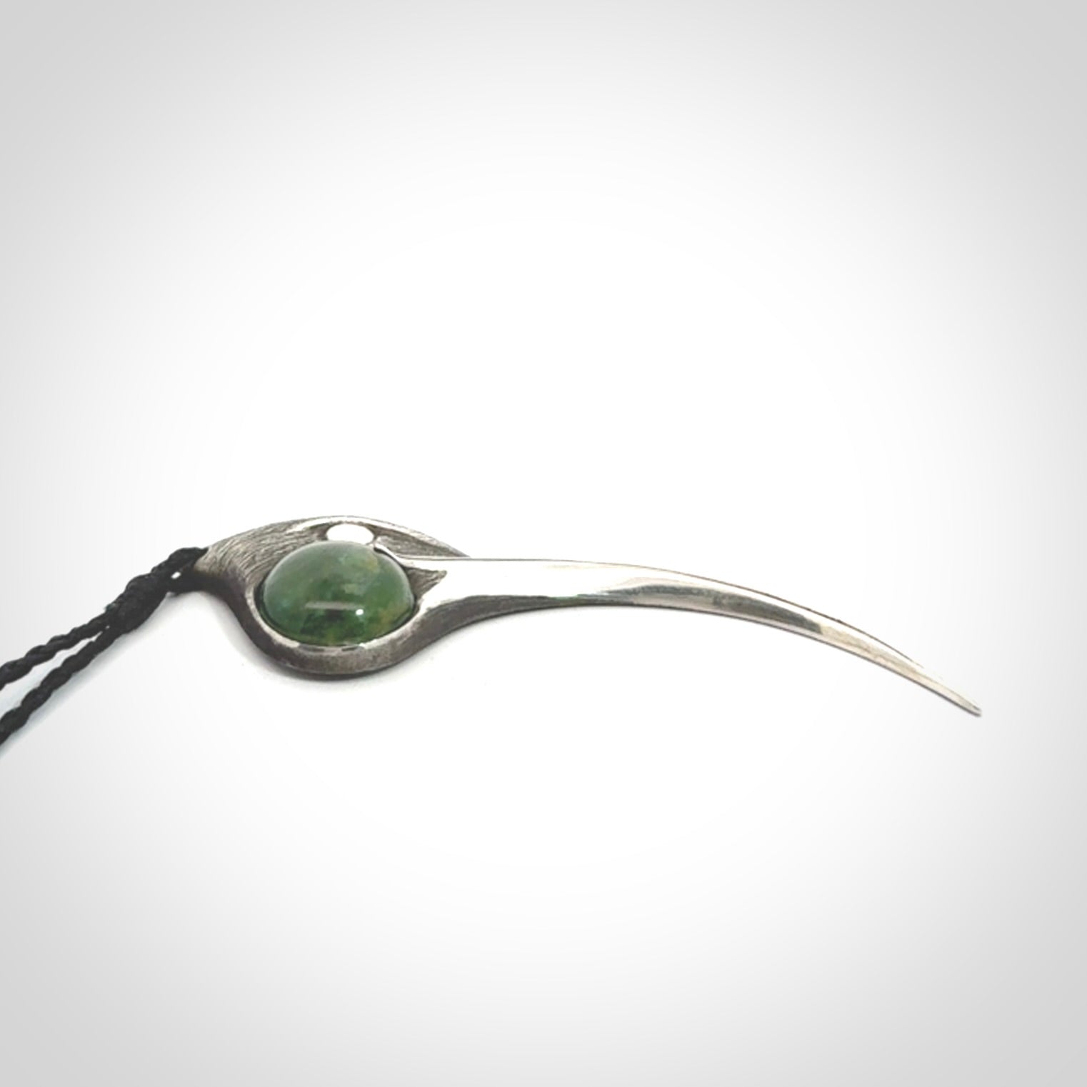 This is a hand carved Sterling Silver Huia bird pendant with New Zealand Jade insert. This is a large sized necklace and is provided with an adjustable black cord.