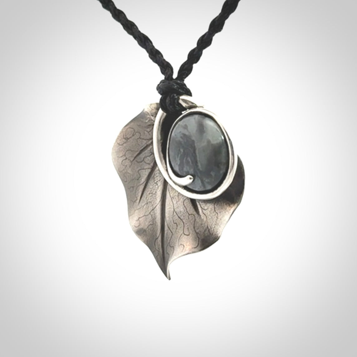 This is a hand carved Sterling Silver Kawakawa leaf pendant with New Zealand Jade insert. This is a medium sized necklace and is provided with an adjustable black cord.