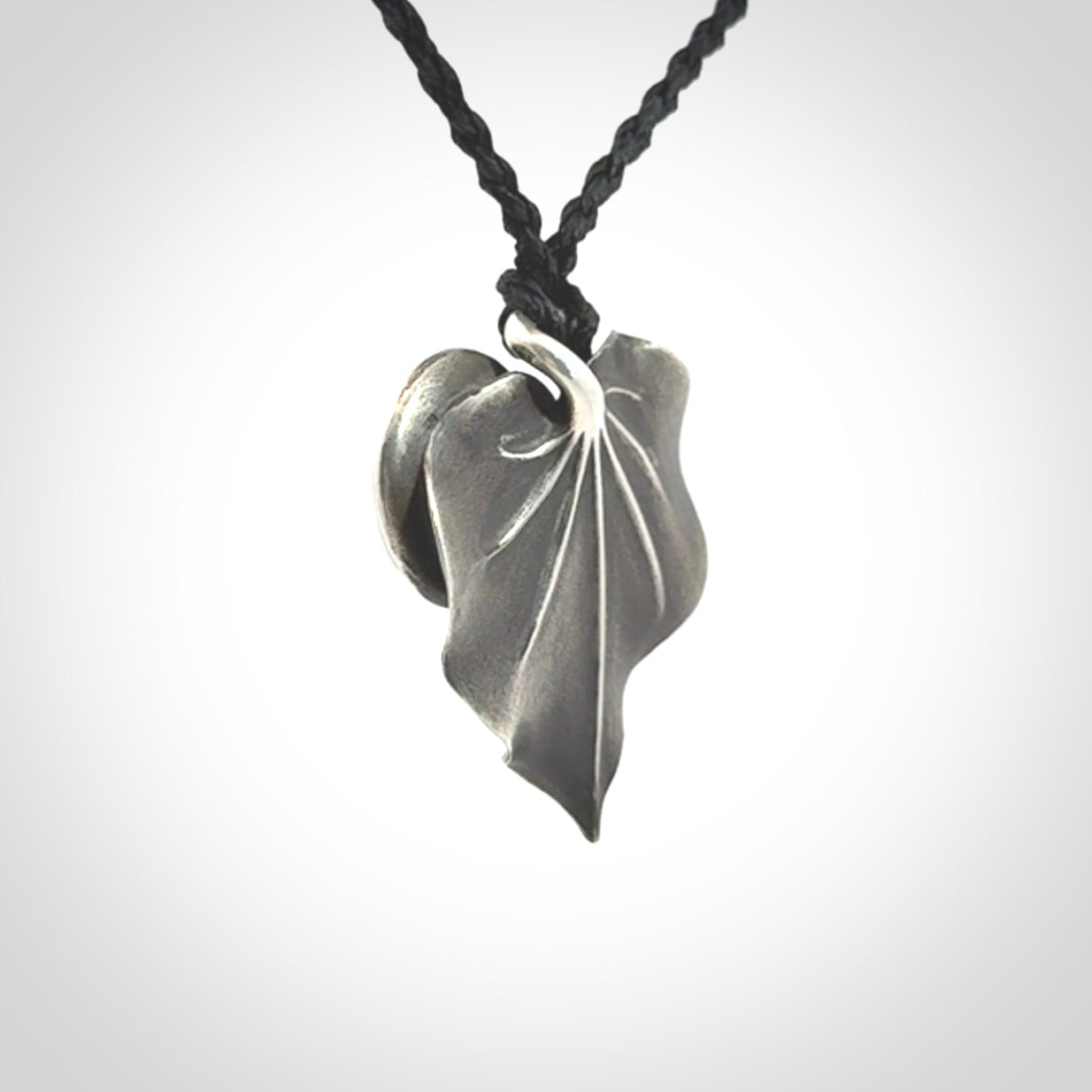 This is a hand carved Sterling Silver Kawakawa leaf pendant with New Zealand Jade insert. This is a medium sized necklace and is provided with an adjustable black cord.