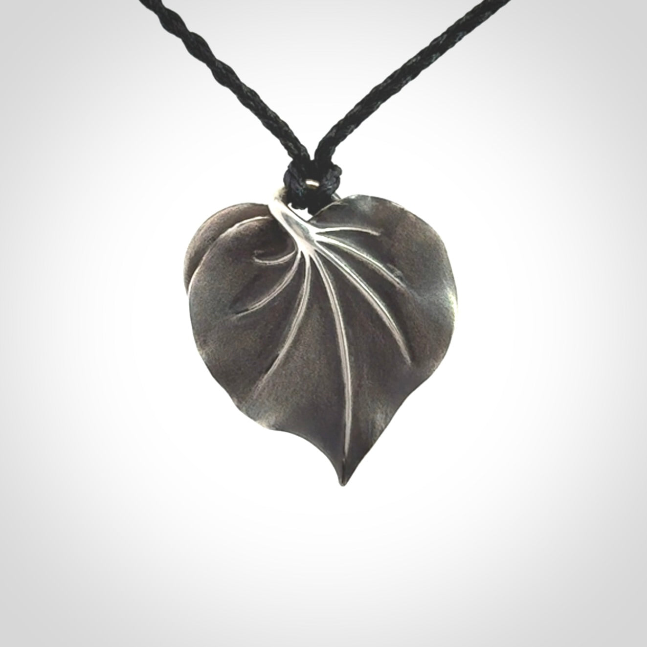This is a hand carved Sterling Silver Kawakawa leaf pendant with New Zealand Jade insert. This is a medium sized necklace and is provided with an adjustable black cord.