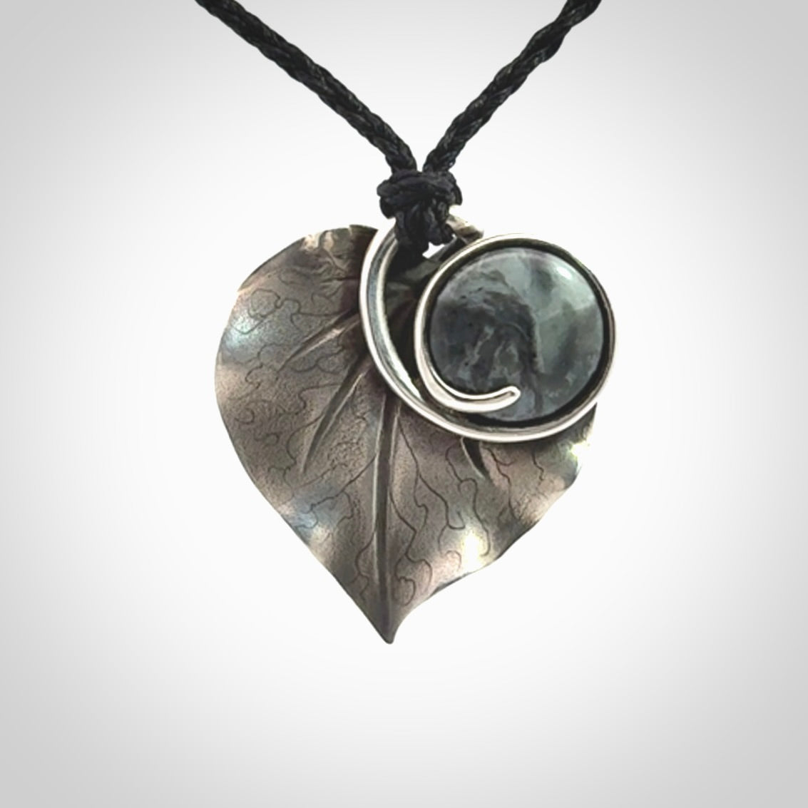 This is a hand carved Sterling Silver Kawakawa leaf pendant with New Zealand Jade insert. This is a medium sized necklace and is provided with an adjustable black cord.