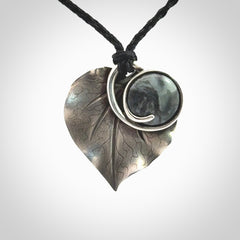 This is a hand carved Sterling Silver Kawakawa leaf pendant with New Zealand Jade insert. This is a medium sized necklace and is provided with an adjustable black cord.