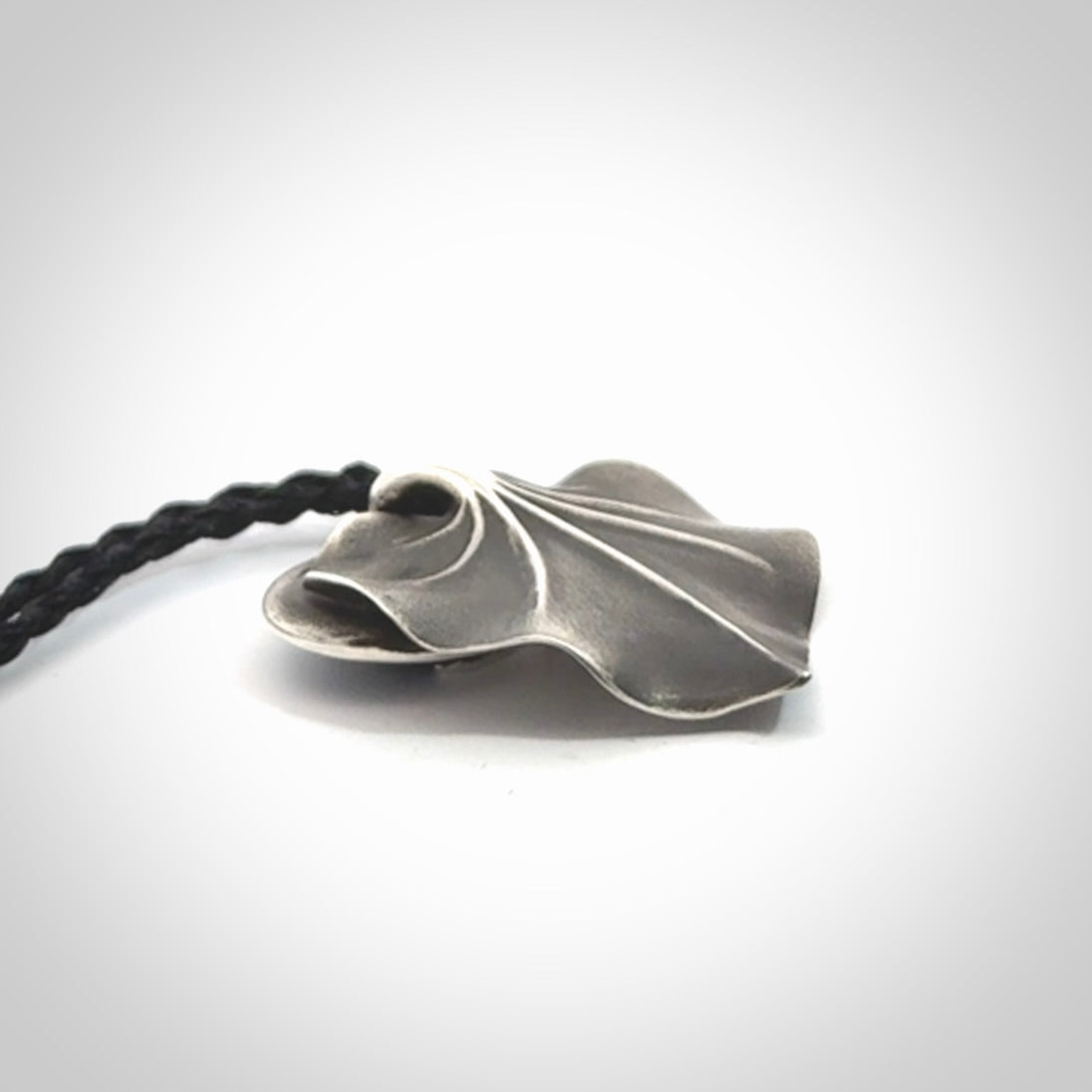 This is a hand carved Sterling Silver Kawakawa leaf pendant with New Zealand Jade insert. This is a medium sized necklace and is provided with an adjustable black cord.