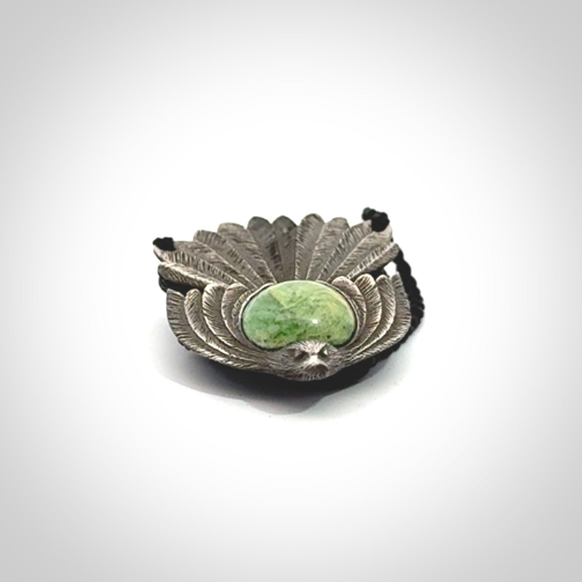 This is a hand carved Sterling Silver Fern fantail pendant with New Zealand Jade insert. This is a medium sized necklace and is provided with an adjustable black cord.