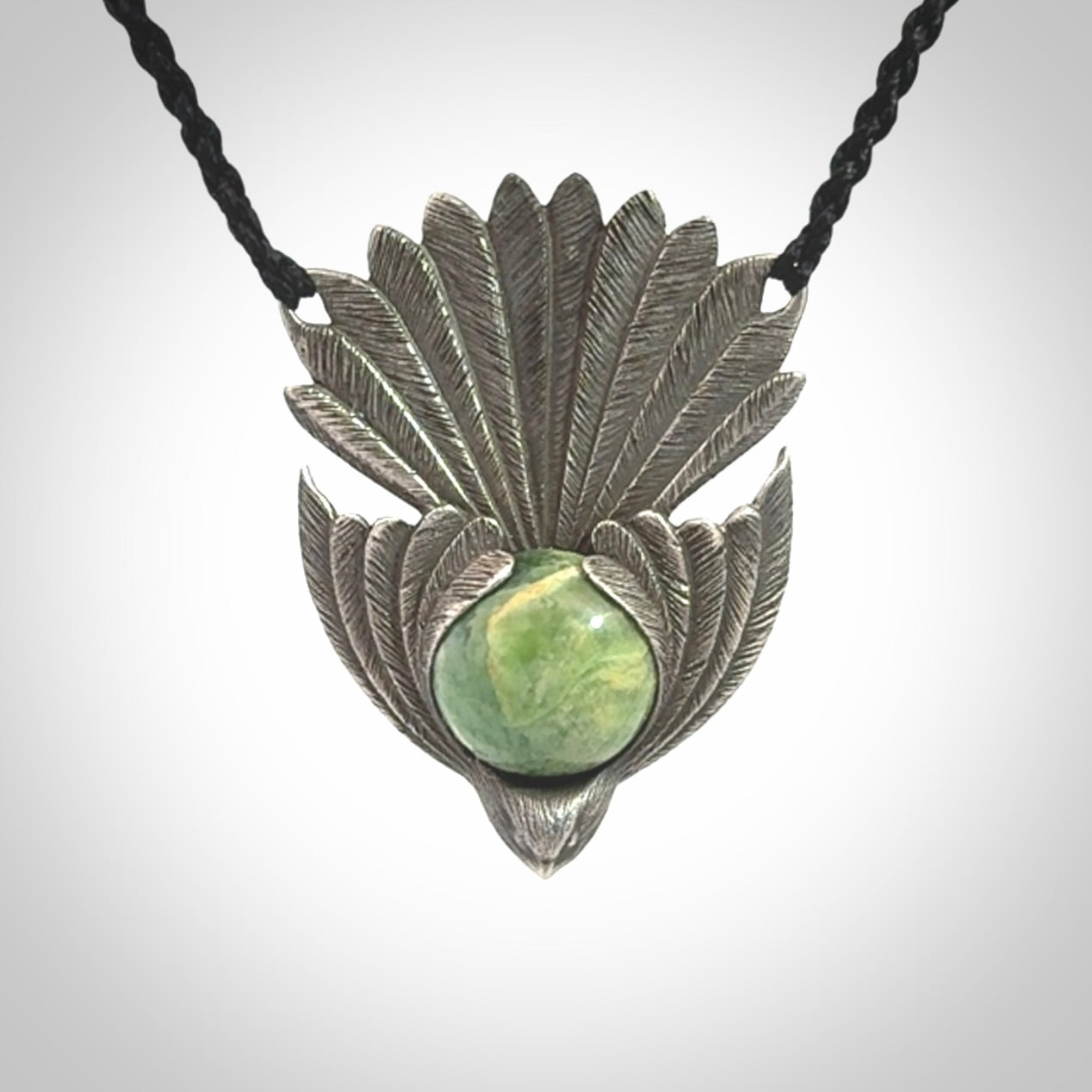 This is a hand carved Sterling Silver Fern fantail pendant with New Zealand Jade insert. This is a medium sized necklace and is provided with an adjustable black cord.