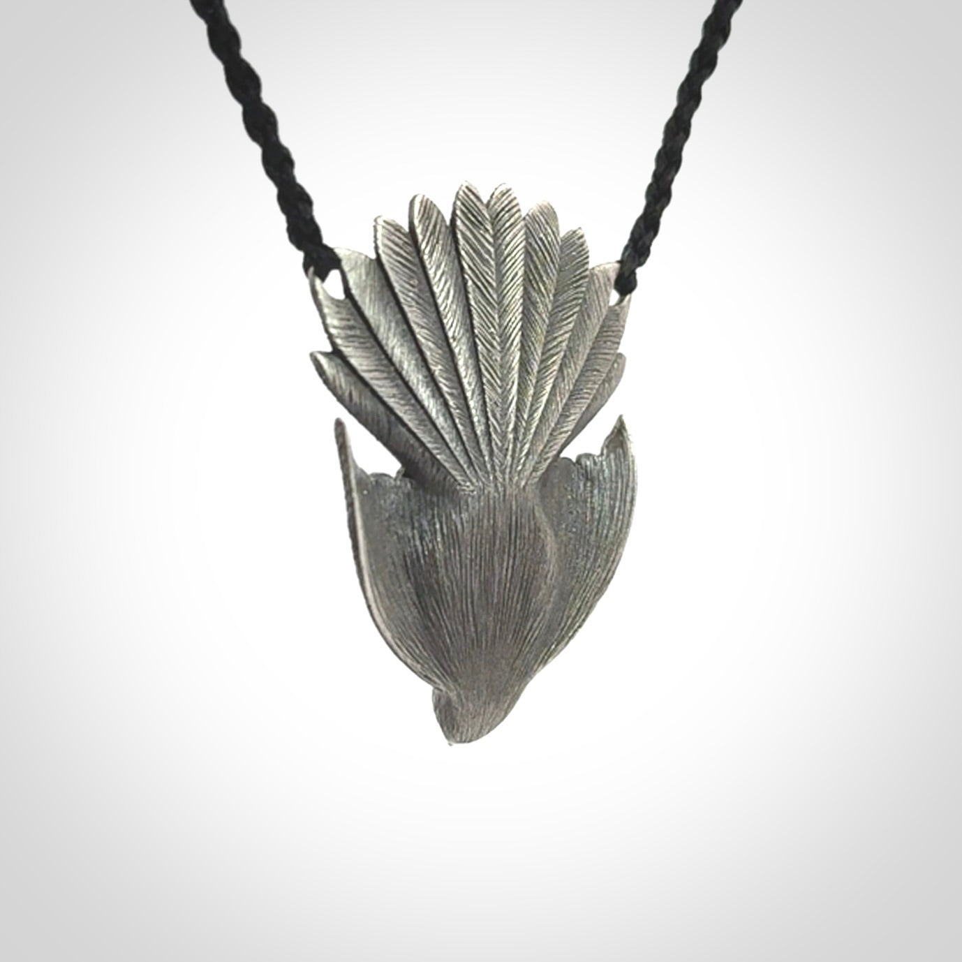 This is a hand carved Sterling Silver Fern fantail pendant with New Zealand Jade insert. This is a medium sized necklace and is provided with an adjustable black cord.