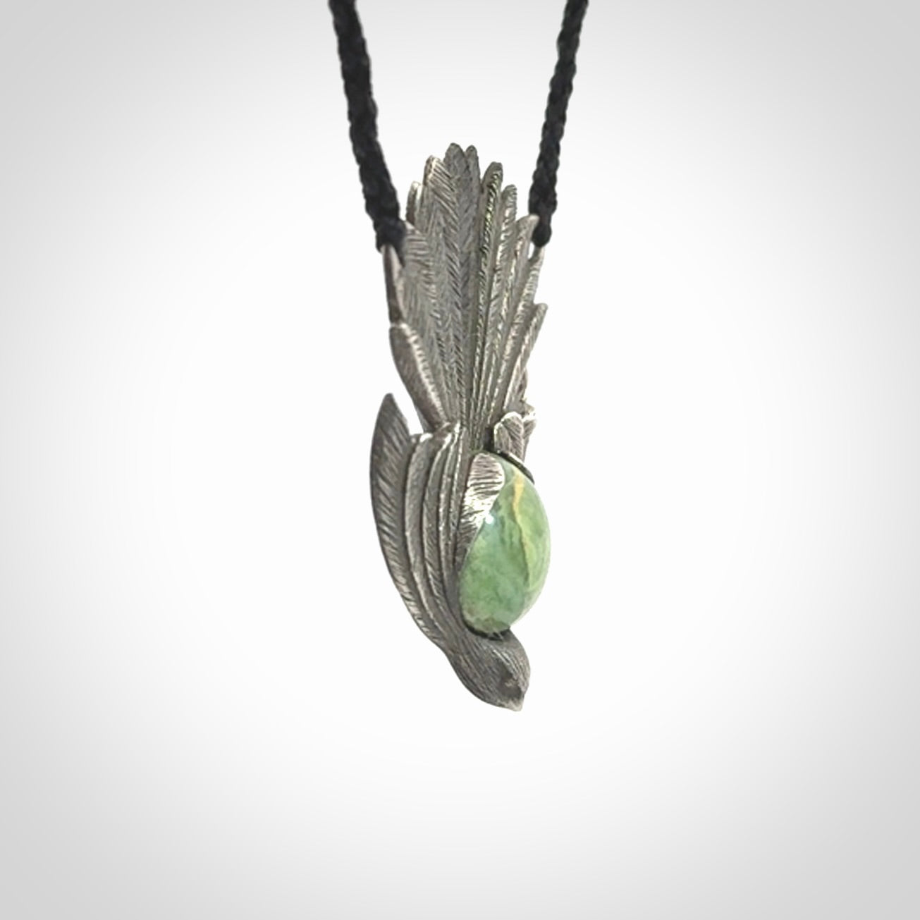 This is a hand carved Sterling Silver Fern fantail pendant with New Zealand Jade insert. This is a medium sized necklace and is provided with an adjustable black cord.