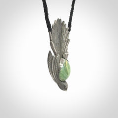 This is a hand carved Sterling Silver Fern fantail pendant with New Zealand Jade insert. This is a medium sized necklace and is provided with an adjustable black cord.