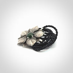 This is a hand carved Sterling Silver Manuka Flower pendant with New Zealand Jade insert. This is a medium sized necklace and is provided with an adjustable black cord.