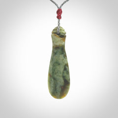This is a sleek and slender hand carved New Zealand Jade mere pendant. The stone is a very beautiful green and the cord is either black, red or grey and is adjustable. The pendant has a light polish and just glows. Provided in a woven kete pouch.