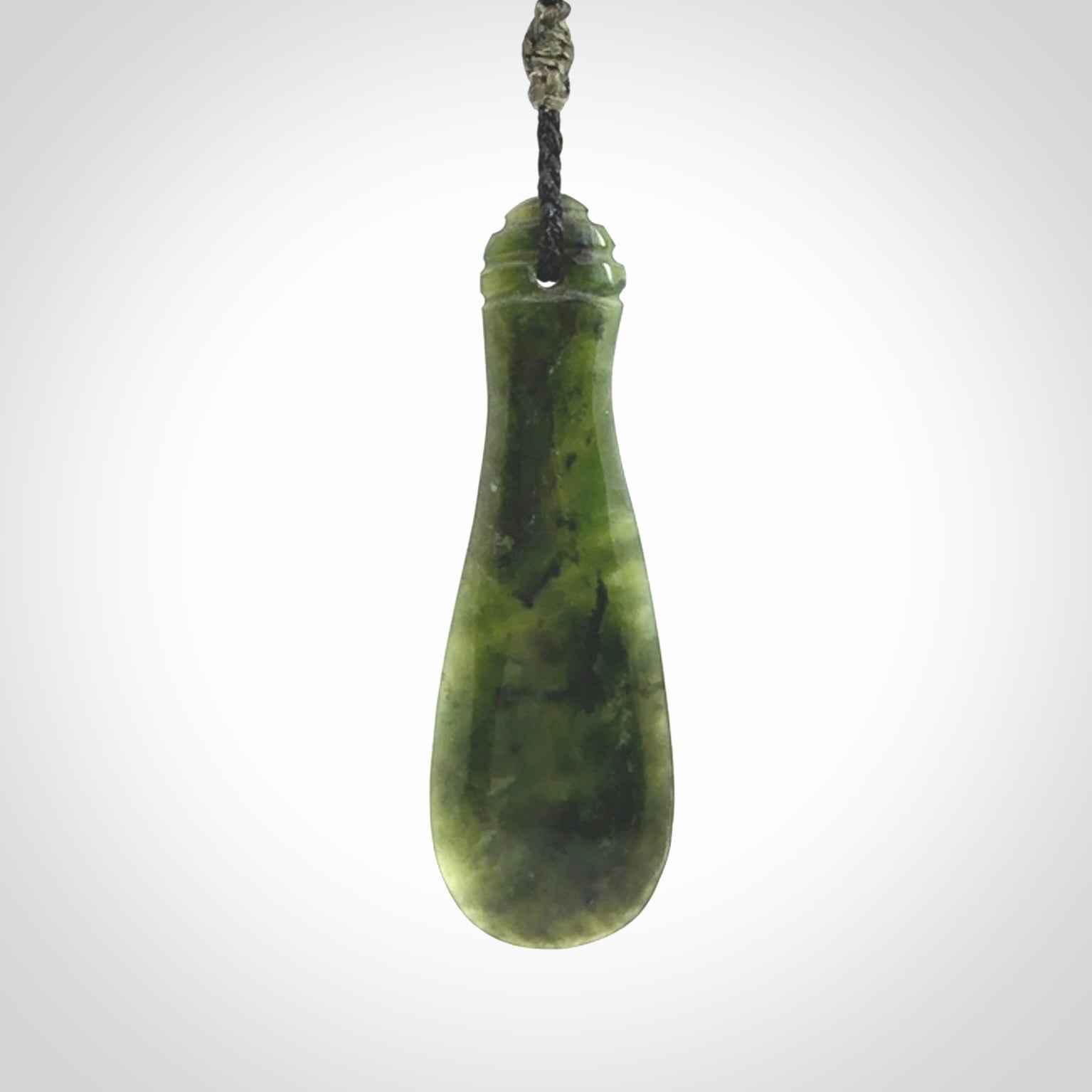 This is a sleek and slender hand carved New Zealand Jade mere pendant. The stone is a very beautiful green and the cord is either black, red or grey and is adjustable. The pendant has a light polish and just glows. Provided in a woven kete pouch.