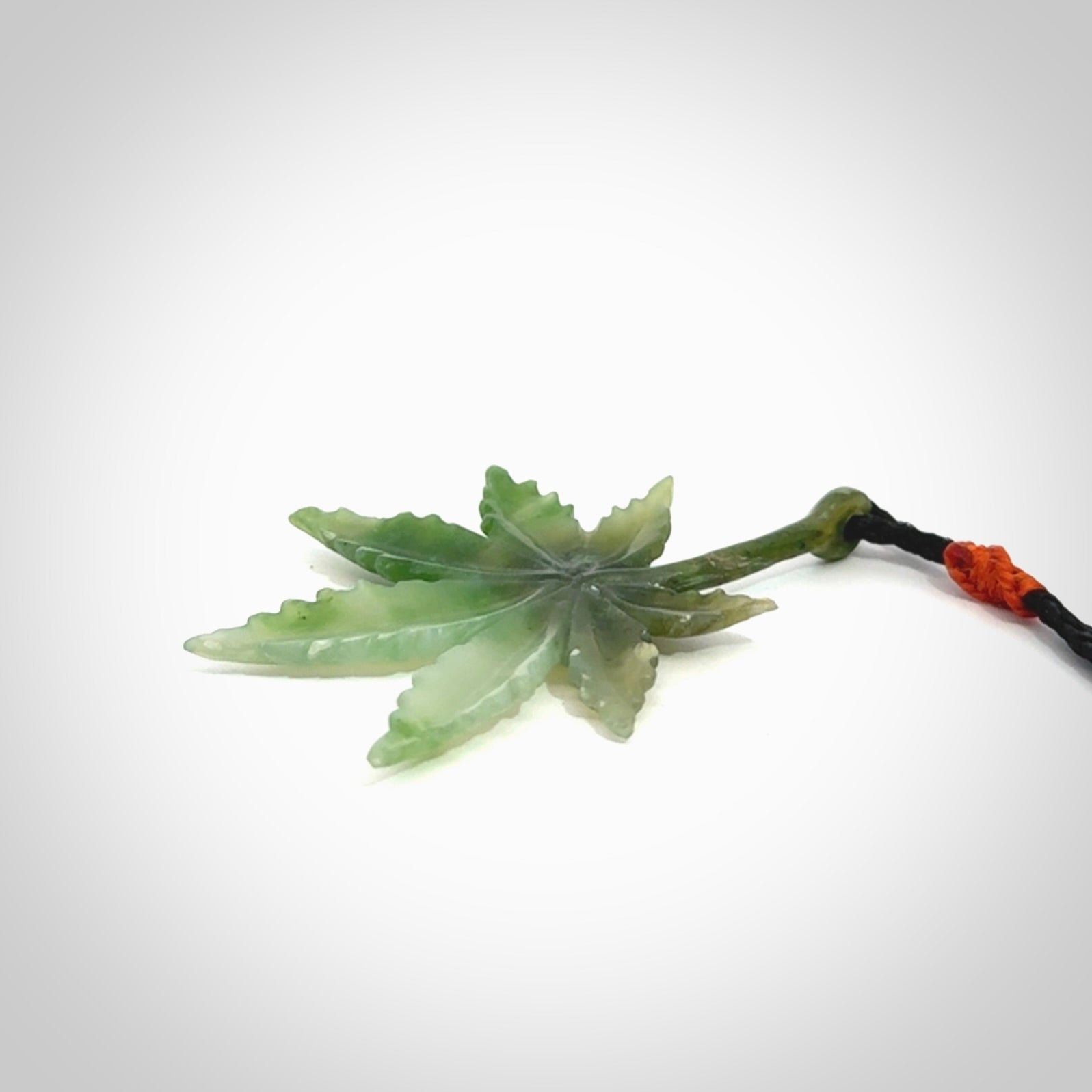 Cannabis Leaf Jade Stone pendant. Handmade jade Cannabis flower jewellery made by NZ Pacific and for sale online. Jade stone Marijuana leaf pendant for men and women. Unique art to wear from NZ Pacific. Delivered on an adjustable cord.
