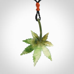Cannabis Leaf Jade Stone pendant. Handmade jade Cannabis flower jewellery made by NZ Pacific and for sale online. Jade stone Marijuana leaf pendant for men and women. Unique art to wear from NZ Pacific. Delivered on an adjustable cord.