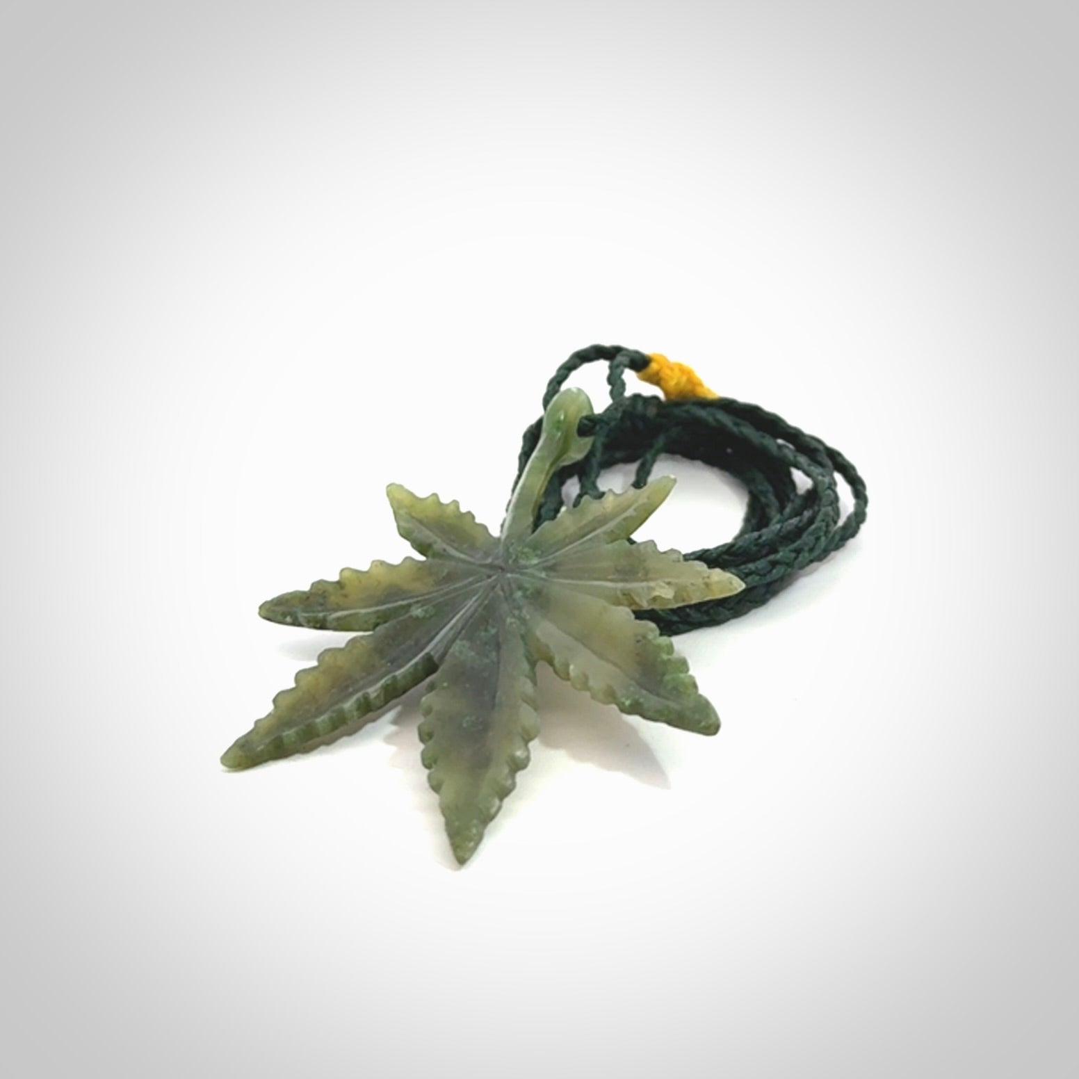 Cannabis Leaf Jade Stone pendant. Handmade jade Cannabis flower jewellery made by NZ Pacific and for sale online. Jade stone Marijuana leaf pendant for men and women. Unique art to wear from NZ Pacific. Delivered on an adjustable cord.