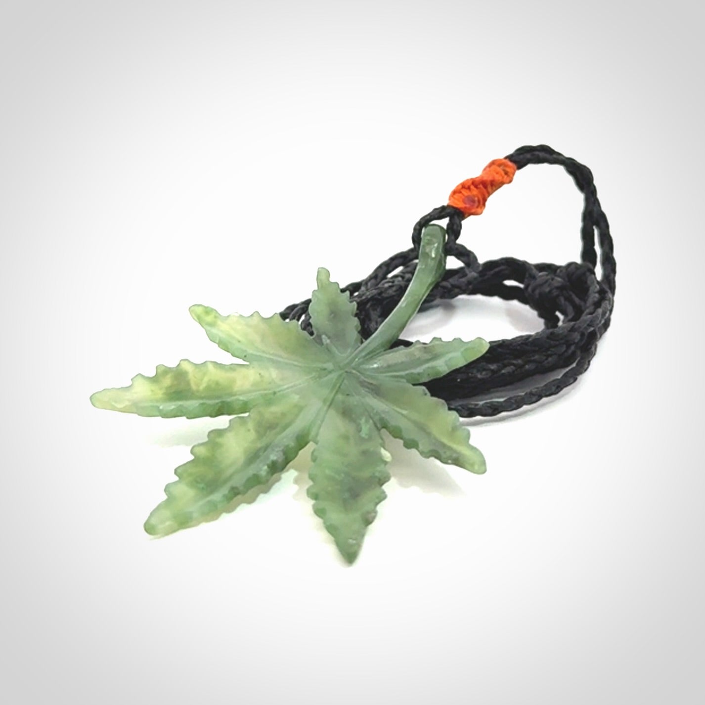 Cannabis Leaf Jade Stone pendant. Handmade jade Cannabis flower jewellery made by NZ Pacific and for sale online. Jade stone Marijuana leaf pendant for men and women. Unique art to wear from NZ Pacific. Delivered on an adjustable cord.