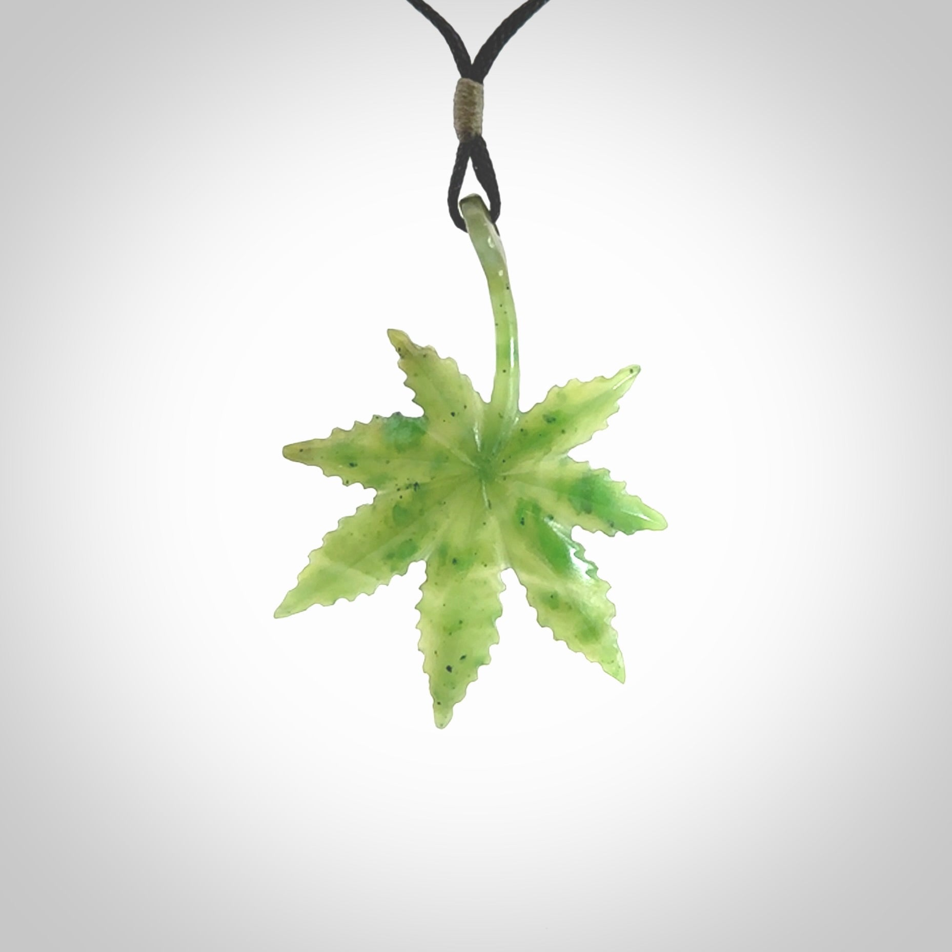 Cannabis Leaf Jade Stone pendant. Handmade jade Cannabis flower jewellery made by NZ Pacific and for sale online. Jade stone Marijuana leaf pendant for men and women. Unique art to wear from NZ Pacific. Delivered on an adjustable black cord.